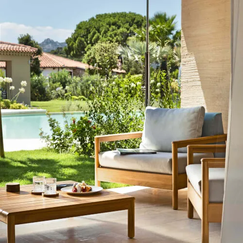 Outdoor seating by the pool at 7Pines Resort Sardinia, encapsulating the tranquility of The Laguna.