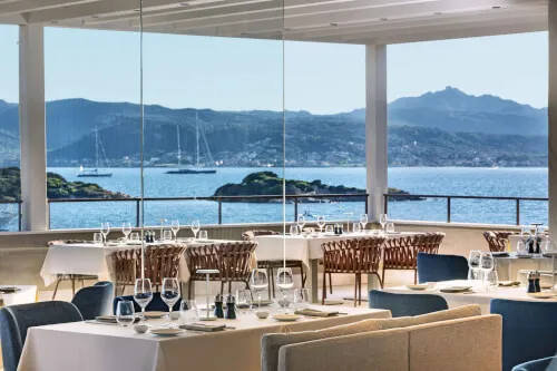 Capogiro restaurant at 7Pines Resort Sardinia with outdoor seating and sea view at sunset