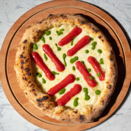Exclusive pizza with hot dogs topping, a blend of Sardinian tradition and innovation at 7Pines Resort Sardinia.