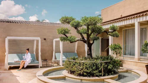 Lush green courtyard at Pure Seven Spa, 7Pines Resort Sardinia, encapsulating relaxation and wellness