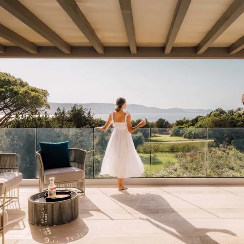 Sposa in bianco sul patio del 7Pines Resort Sardegna, esplora offerte speciali.