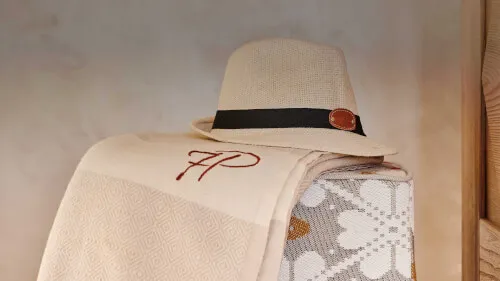 Beige hat and elegant blanket featuring 7P logo at 7Pines Resort Sardinia.